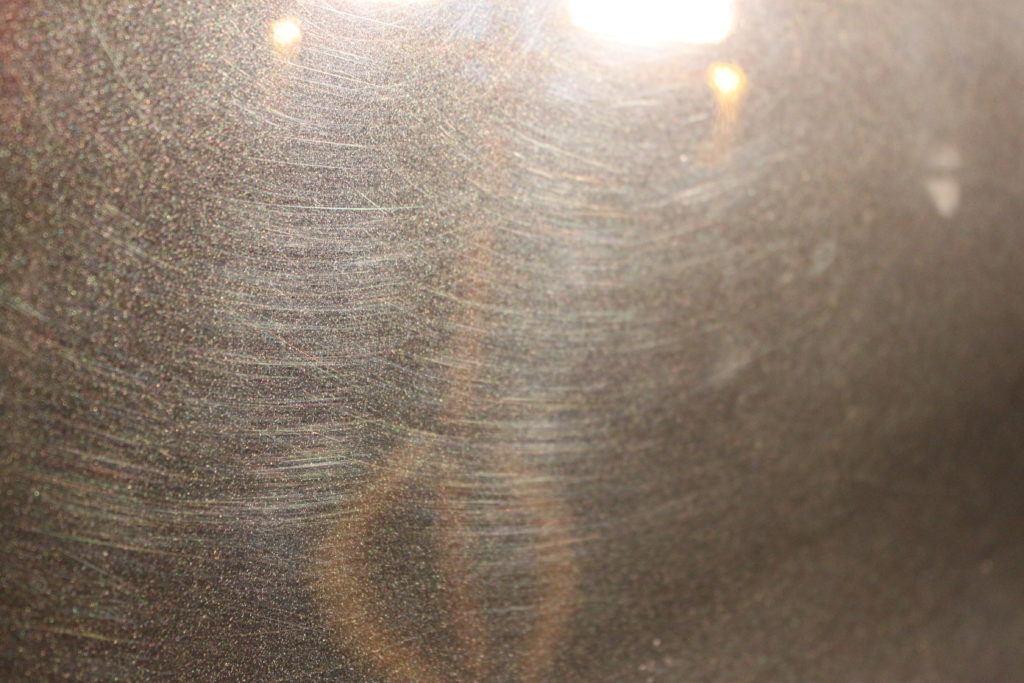 Close up of paint swirls under a work light.
