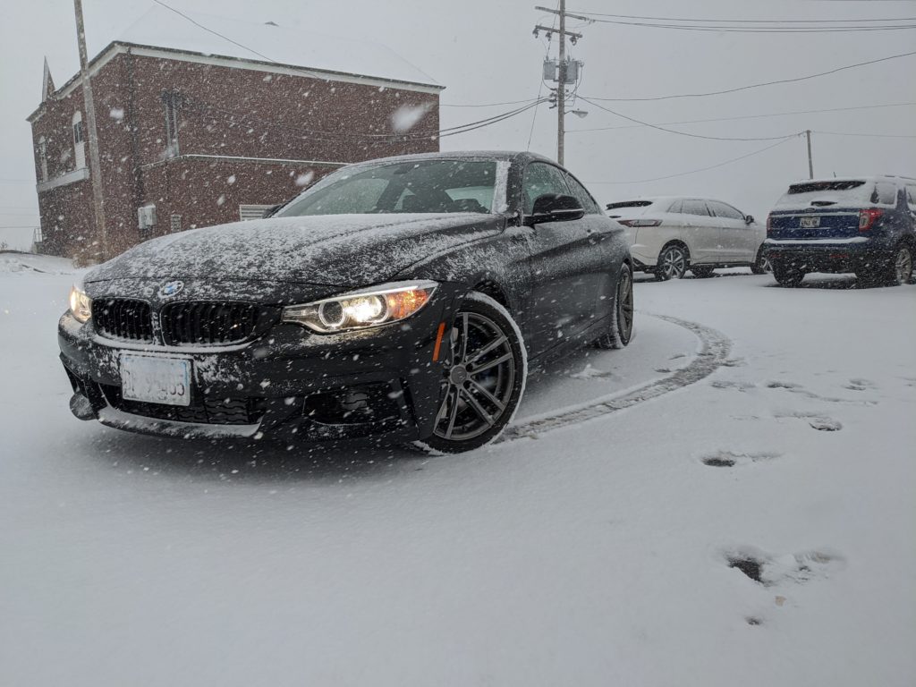 Black BMW 435 in snow with winter tires.